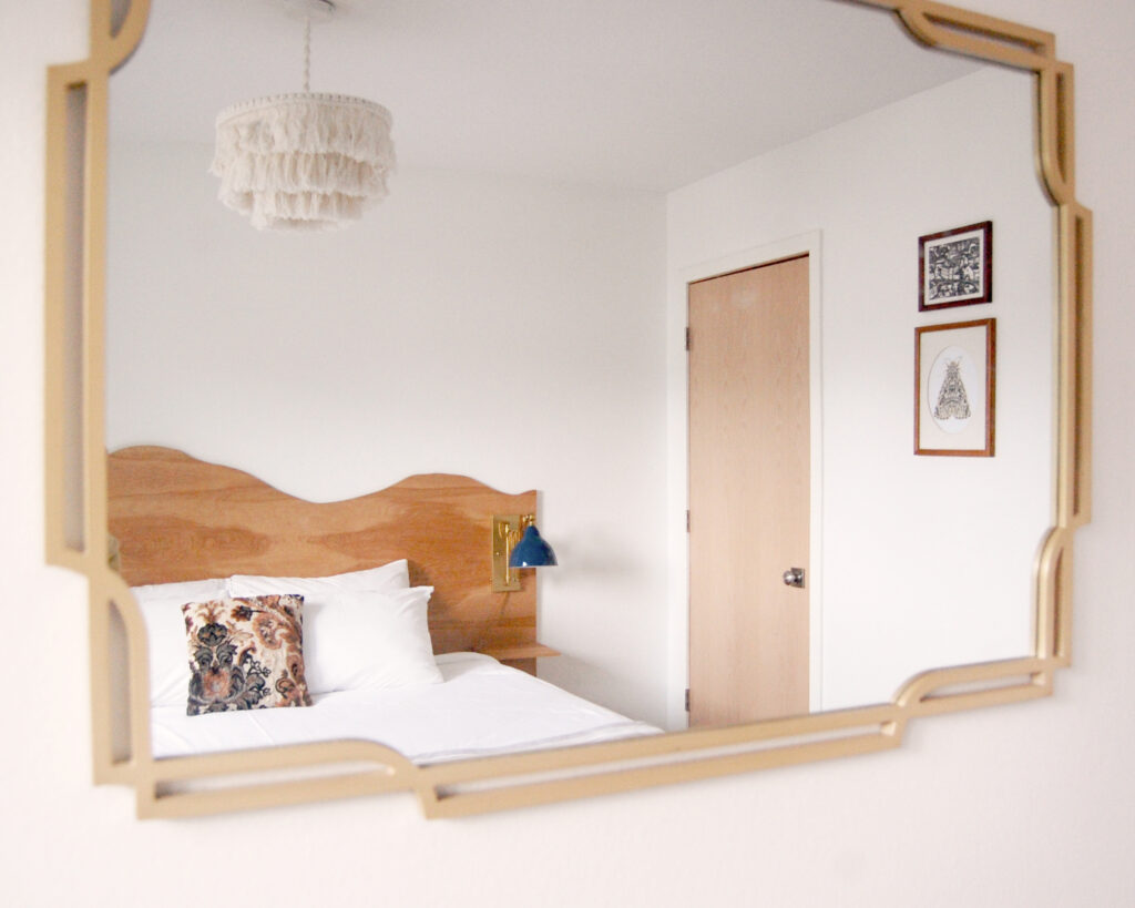 A styled bedroom designed with wall art and mirror
